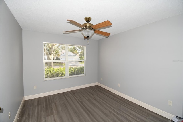 empty room with ceiling fan, dark hardwood / wood-style flooring, and a textured ceiling