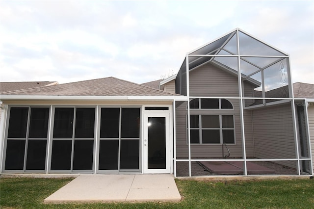 rear view of house with a patio, a lanai, and a lawn