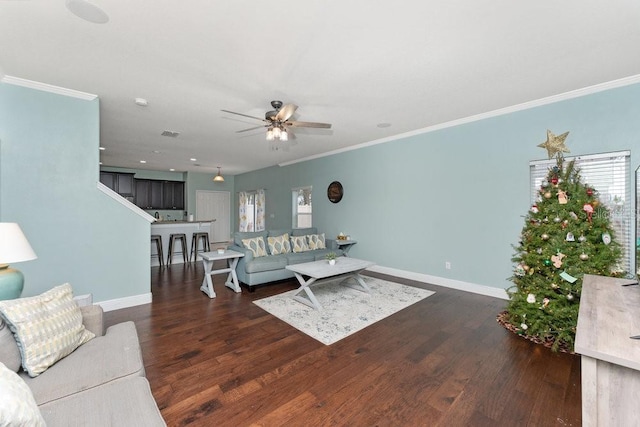 living room featuring dark hardwood / wood-style flooring, ceiling fan, and crown molding