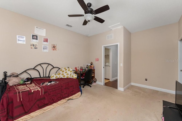 bedroom with ceiling fan, light colored carpet, and washer / dryer