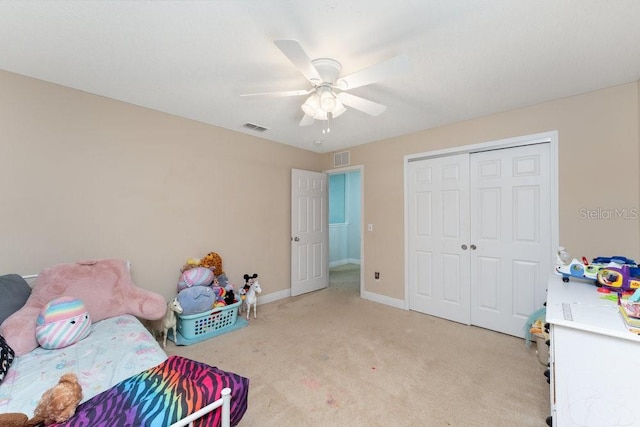 carpeted bedroom with ceiling fan and a closet