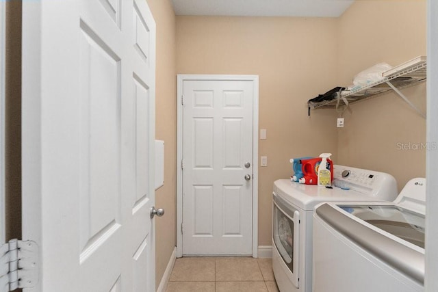 laundry area featuring separate washer and dryer and light tile patterned floors