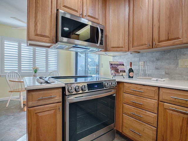 102 Cedar Way, Yalaha, FL 34797 - kitchen featuring stainless steel appliances, backsplash, light countertops, and brown cabinetry