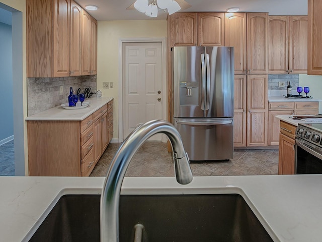 kitchen featuring backsplash, stainless steel appliances, ceiling fan, sink, and light tile patterned floors