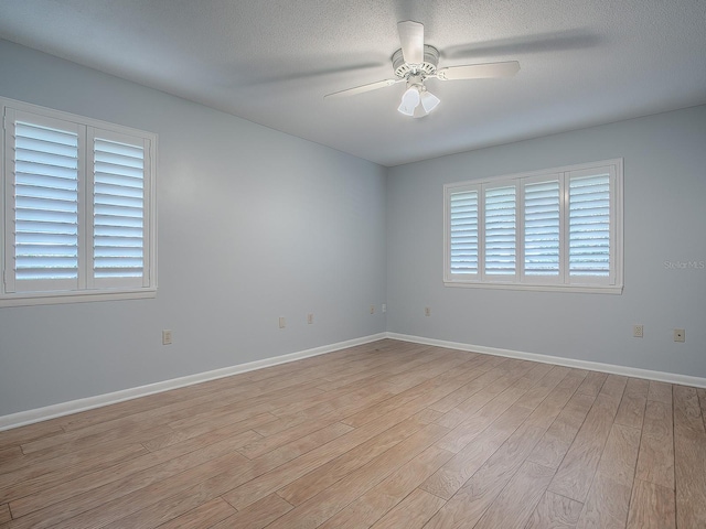 empty room featuring ceiling fan, a textured ceiling, and light hardwood / wood-style flooring