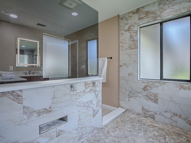 bathroom with sink and tiled shower