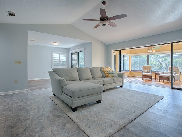 living room featuring plenty of natural light, ceiling fan, and lofted ceiling