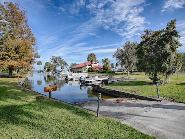 view of dock featuring a water view and a yard