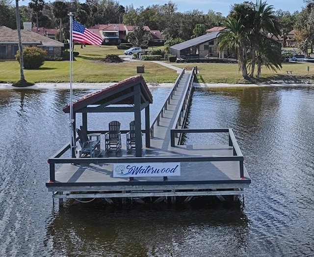 dock area featuring a lawn and a water view