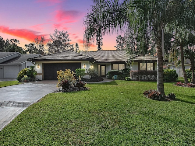 single story home with a lawn and a garage