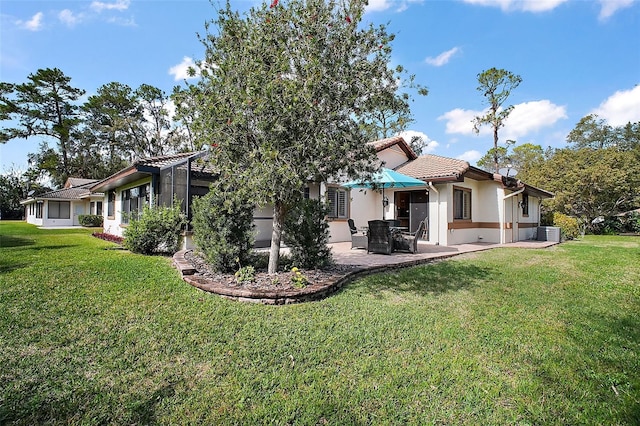 102 Cedar Way, Yalaha, FL 34797 - back of house featuring a patio, stucco siding, a yard, and a tiled roof