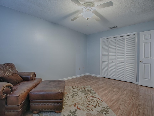 102 Cedar Way, Yalaha, FL 34797 - living area with light wood-style floors, ceiling fan, and a textured ceiling