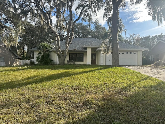 ranch-style house featuring a front yard and a garage