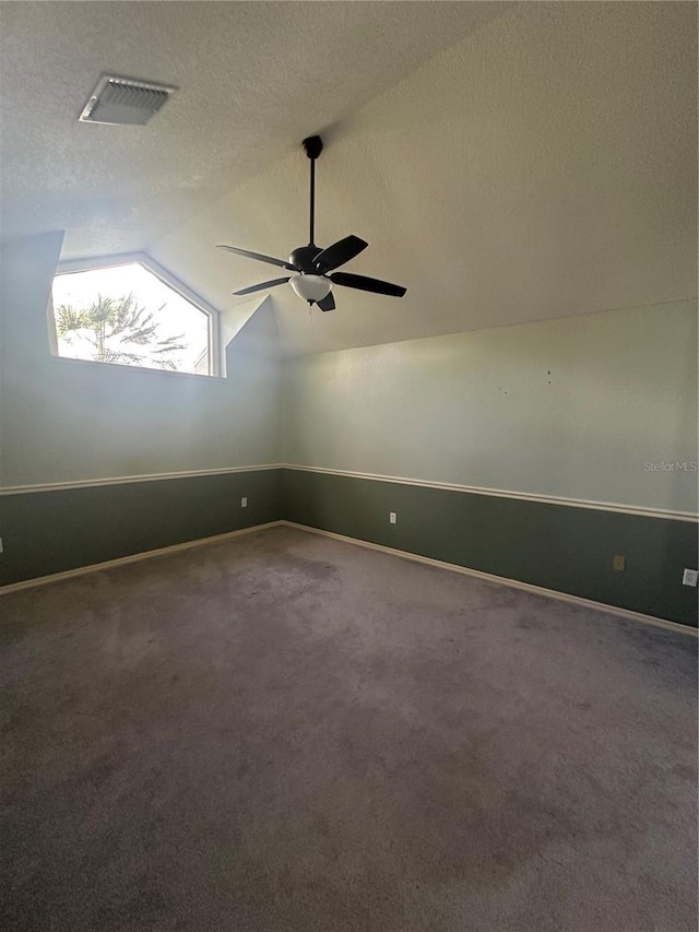 unfurnished room featuring carpet flooring, a textured ceiling, ceiling fan, and lofted ceiling