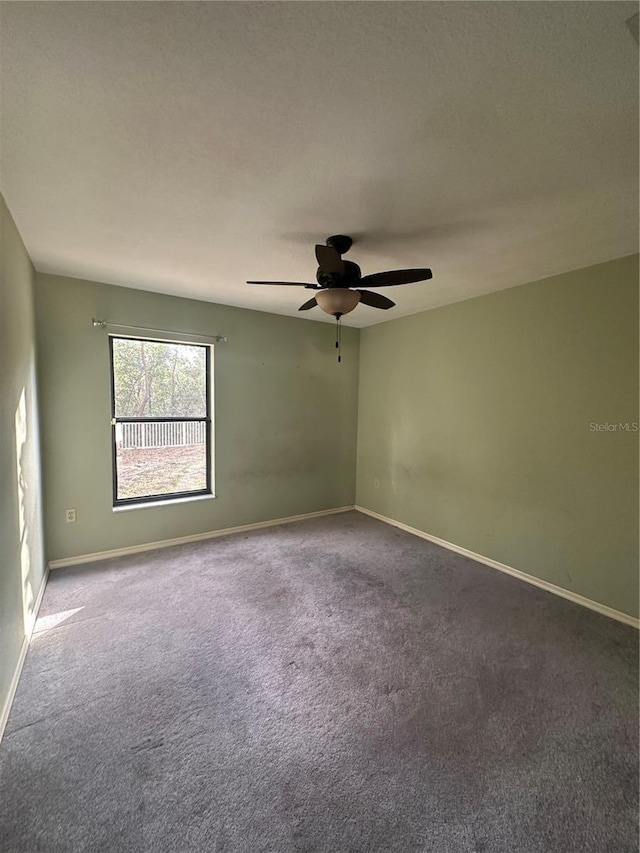 carpeted spare room with ceiling fan