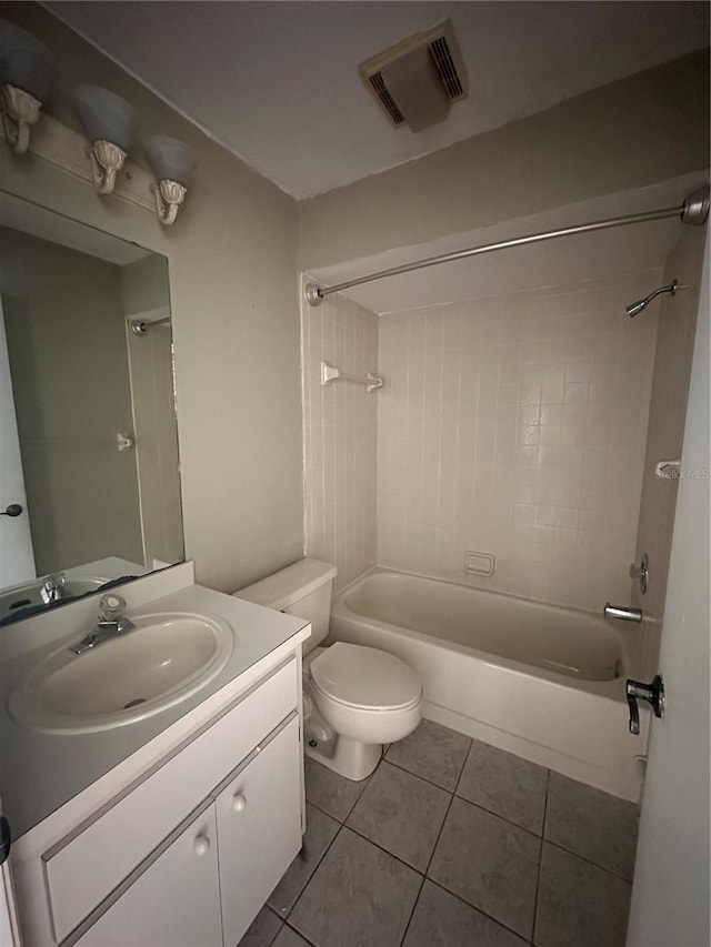 full bathroom with tile patterned floors, tiled shower / bath combo, toilet, and vanity