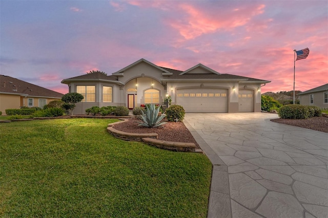 view of front of home featuring a lawn and a garage