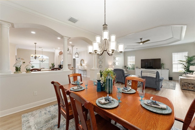 dining space with ceiling fan with notable chandelier, crown molding, and light hardwood / wood-style flooring