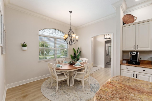 dining room featuring crown molding, light hardwood / wood-style flooring, and a notable chandelier