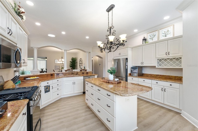 kitchen featuring white cabinets, appliances with stainless steel finishes, light wood-type flooring, and a kitchen island