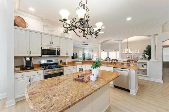 kitchen featuring kitchen peninsula, hanging light fixtures, a chandelier, and appliances with stainless steel finishes