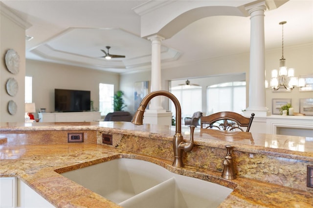 kitchen featuring sink, ceiling fan with notable chandelier, a healthy amount of sunlight, and decorative light fixtures