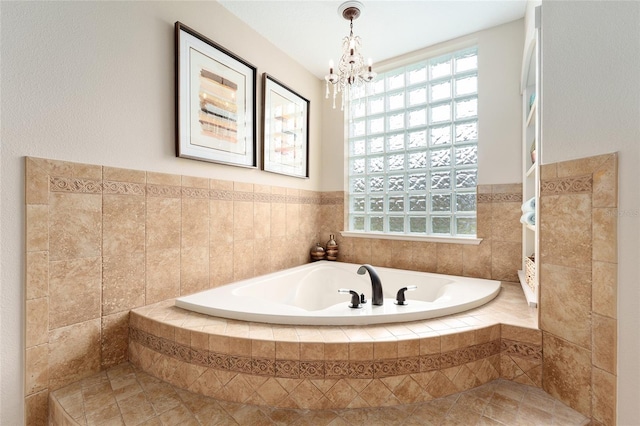 bathroom featuring tiled tub and a chandelier