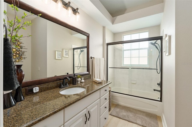 bathroom with hardwood / wood-style floors, vanity, and combined bath / shower with glass door