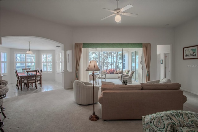 tiled living room with ceiling fan and decorative columns