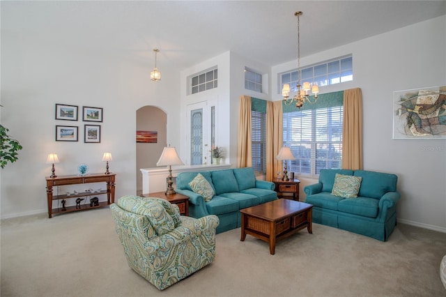 carpeted living room with an inviting chandelier and a high ceiling