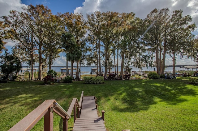 dock area with a water view and a yard