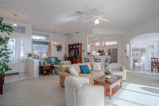 living room with light carpet and ceiling fan with notable chandelier