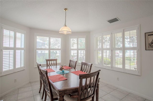 dining room with light tile patterned floors and a textured ceiling