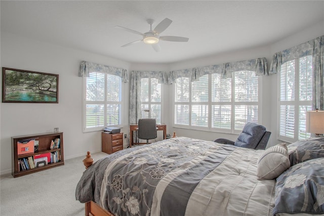 carpeted bedroom with ceiling fan and multiple windows