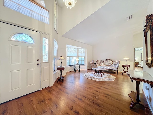 entrance foyer with a chandelier, a high ceiling, and hardwood / wood-style flooring