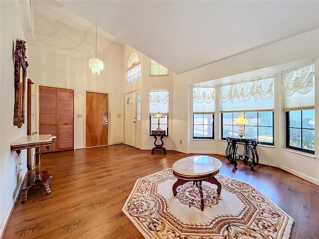 living room featuring hardwood / wood-style floors, a high ceiling, and an inviting chandelier