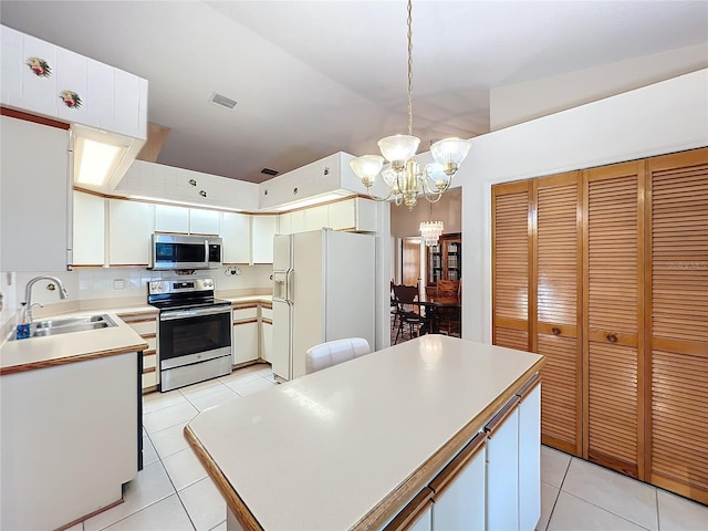 kitchen featuring pendant lighting, white cabinets, sink, appliances with stainless steel finishes, and a notable chandelier