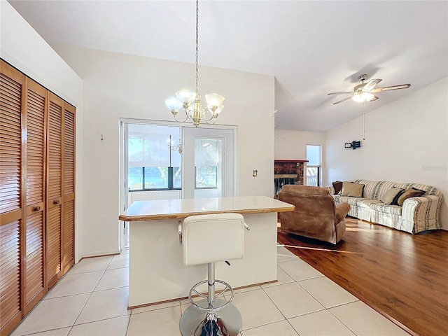 kitchen featuring a breakfast bar, pendant lighting, light hardwood / wood-style flooring, and plenty of natural light