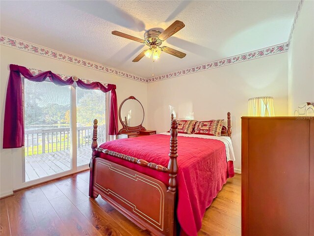 bedroom with access to exterior, ceiling fan, a textured ceiling, and hardwood / wood-style flooring