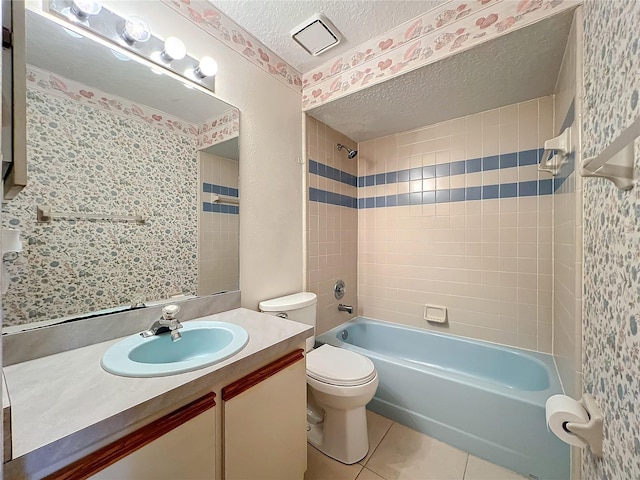 full bathroom with tile patterned floors, tiled shower / bath combo, a textured ceiling, and toilet