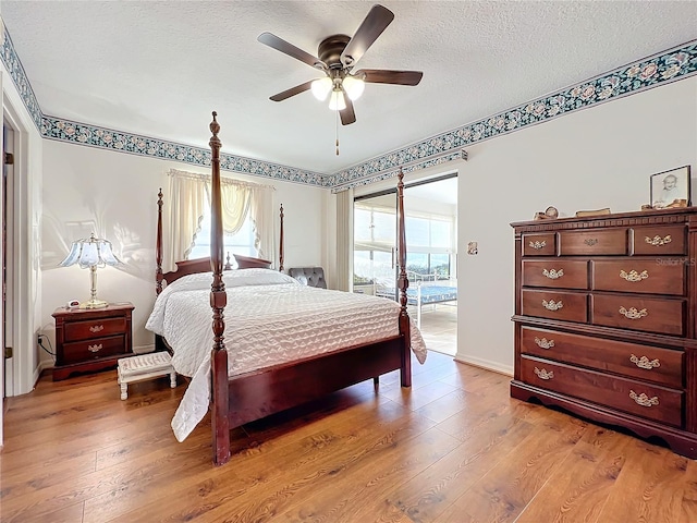 bedroom with ceiling fan, light hardwood / wood-style floors, and multiple windows