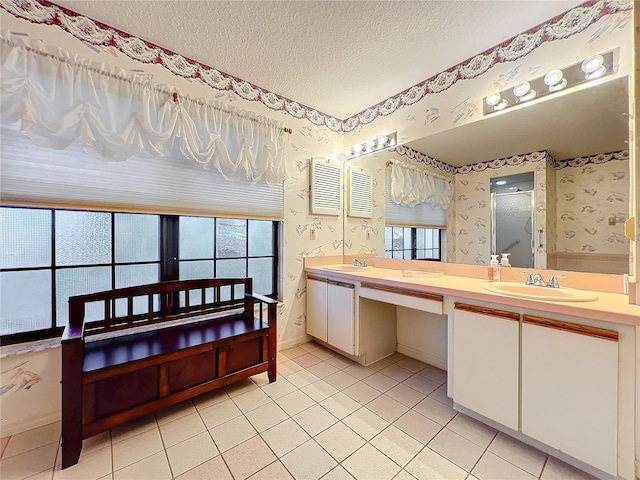 bathroom featuring tile patterned floors, vanity, a textured ceiling, and a wealth of natural light