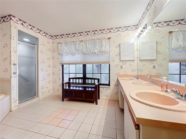 bathroom with independent shower and bath, a textured ceiling, and a wealth of natural light