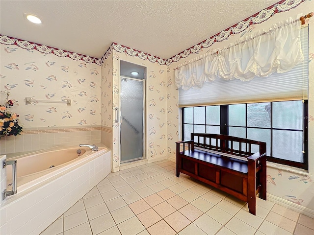 bathroom with shower with separate bathtub, a textured ceiling, and tile patterned floors