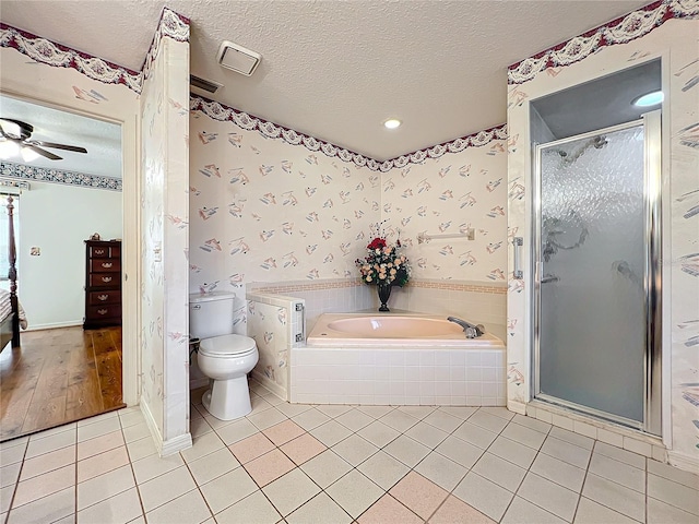 bathroom featuring tile patterned floors, ceiling fan, separate shower and tub, toilet, and a textured ceiling