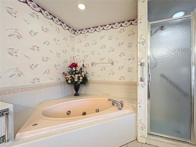 bathroom with a textured ceiling and independent shower and bath