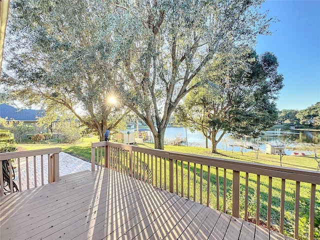 wooden terrace with a yard and a water view