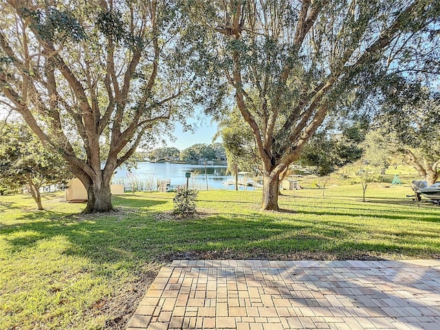 view of yard featuring a water view and a patio