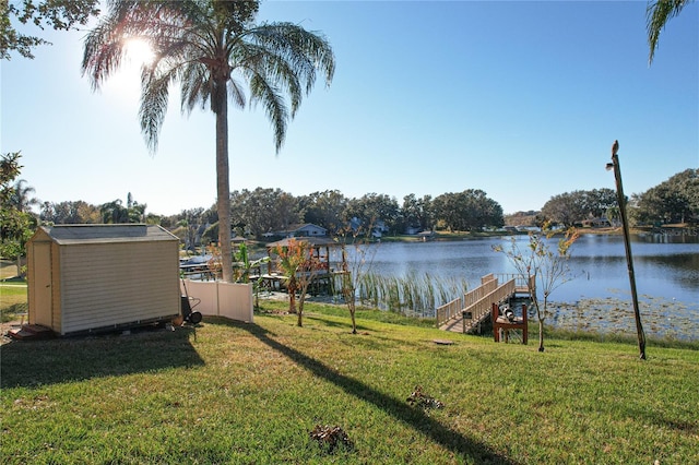 view of yard featuring a water view and a shed