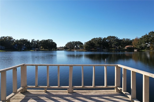 view of dock with a balcony and a water view